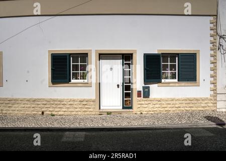 Quiaios, Portugal - 14. August 2022: Haus in gutem Zustand mit weiß lackierten Türen und Fenstern mit grünen Fensterläden Stockfoto