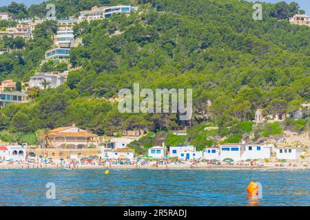 Javea, Alicante, Spanien. 22. Mai 2022 - die Bucht, Cala Portitxol, ein kleiner Strand mit Fischergebäuden und Küstenhütten inmitten der Kiefern am Stockfoto