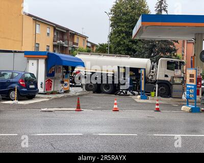 Cremona, Italien - Mai 2023 Tankwagen liefert Kraftstoff an ip-Tankstelle in Italien an Regentage. Stockfoto