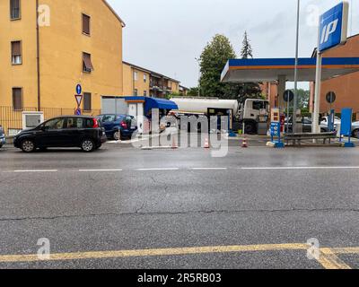 Cremona, Italien - Mai 2023 Tankwagen liefert Kraftstoff an ip-Tankstelle in Italien an Regentage. Stockfoto