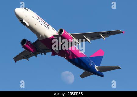 Ein Flugzeug mit seiner Heckflosse, die aus einem hellblauen und pinkfarbenen Himmelshintergrund ragt Stockfoto