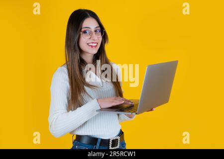 Porträt einer hübschen kaukasierin, die einen Laptop hält. Junge schöne Geschäftsfrau, Büroangestellte, Designerin, Programmiererin, Texterin. Stockfoto