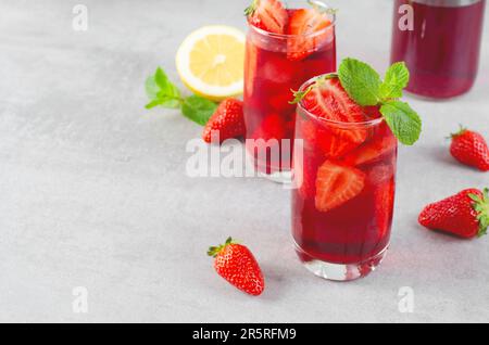 Erdbeergetränk, erfrischender Cocktail, Limonade, Eistee, Rotes kühles Sommergetränk auf hellem Hintergrund Stockfoto