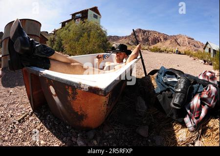 Ein Cowboy, der in der Sonne badet, im Süden Nevadas, mit seinen Waffen in der Nähe Stockfoto