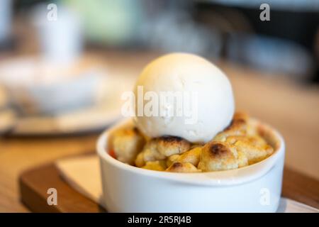 Erdbeerkuchen mit Eiscreme auf der Oberseite, serviert in einer weißen Schüssel Stockfoto