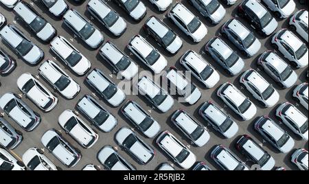 Luftaufnahme des Neuwagenbestands auf dem Werksparkplatz. Oben geparkte Autos. Automobilindustrie. Logistikgeschäft. Neue importieren oder exportieren Stockfoto