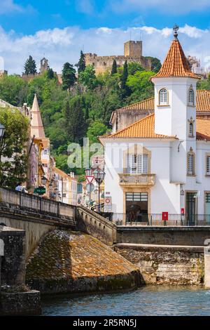 Portugal, Tomar, ehemaliger Sitz des Templerordens, Ponte Velha oder Dom Manuel Brücke am Fluss Nabao, ist eines der Symbole der Stadt, die mittelalterliche Burg im Hintergrund Stockfoto