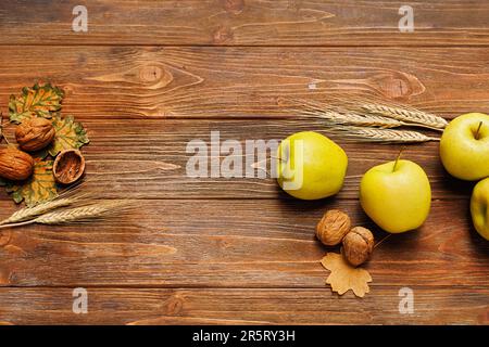 Herbstleben mit Äpfeln, Pfirsichen, Gerstenohren, Ahorn- und Eichenblättern, Walnüssen auf Holzhintergrund Stockfoto