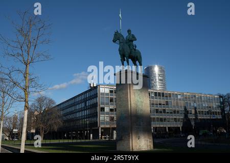 Ein Schwarzweißbild einer majestätischen Reiterstatue eines Mannes auf einem Pferd vor einem imposanten Gebäude Stockfoto