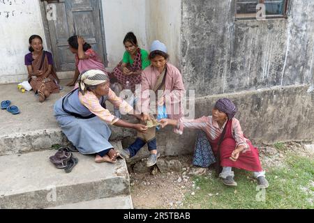 Damen aus dem Khasi-Stamm sitzen vor dem Eingang zum lokalen Haus und teilen Betelnüsse zum Kauen in der region shillong in meghalaya, indien Stockfoto