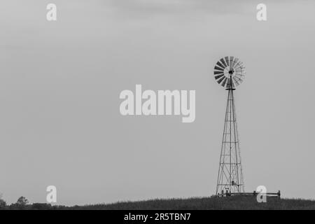 Im Amish Country im ländlichen Ohio in den USA steht eine einsame Windmühle vor einem bedeckten Himmel. Stockfoto