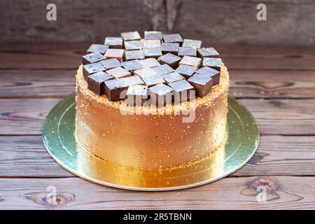 Schokoladen-Brownie-Kuchen mit Schokoriegeln und Trüffeln im rustikalen Hintergrund. Kuchen für Schokoladenliebhaber Stockfoto