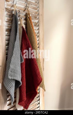 Eine Nahaufnahme von Küchenhandtüchern, die an einer Holzwand hing Stockfoto