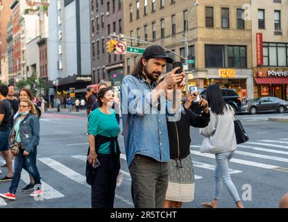 Astronomieliebhaber riskieren Leben und Gliedmaßen, während sie in der West 23. Street in Chelsea in New York stehen, um die erste Nacht des Sonnenuntergangs von Manhattan am Montag, den 29. Mai 2023 zu fotografieren. Zweimal im Jahr steht die Sonne bei Sonnenuntergang am Netz der Stadt und untergeht inmitten der Straßen. Das Ereignis, der Name des Hayden Planetarium von Neil deGrasse Tyson, findet 22 Tage vor und 21 Tage nach der Sommersonnenwende statt. Aufgrund des 30-Grad-Winkels des Stadtgitters ist es nicht gerade Ost-West-Nord-Süd. (© Richard B. Levine Stockfoto