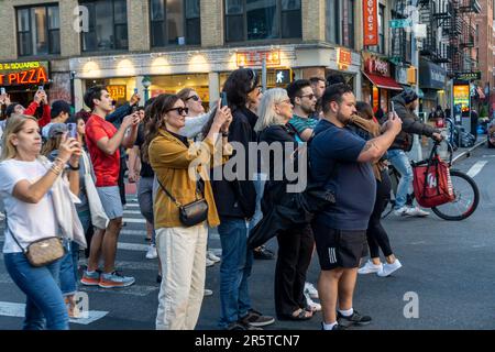 Astronomieliebhaber riskieren Leben und Gliedmaßen, während sie in der West 23. Street in Chelsea in New York stehen, um die zweite Nacht des Sonnenuntergangs in Manhattan am Dienstag, den 30. Mai 2023 zu fotografieren. Zweimal im Jahr steht die Sonne bei Sonnenuntergang am Netz der Stadt und untergeht inmitten der Straßen. Das Ereignis, der Name des Hayden Planetarium von Neil deGrasse Tyson, findet 22 Tage vor und 21 Tage nach der Sommersonnenwende statt. Aufgrund des 30-Grad-Winkels des Stadtgitters ist es nicht gerade Ost-West-Nord-Süd. (© Richard B. Levine Stockfoto