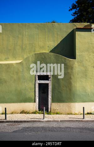 Eine Tür in einer bemalten grünen Mauer in Lissabon Stockfoto