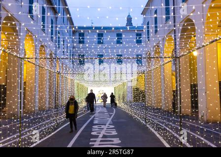 Eine Gruppe von Leuten, die abends eine ruhige Straße entlanggehen Stockfoto