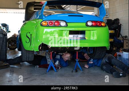 Ein Detail eines grünen Toyota Supra in den Gruben in der Garage Stockfoto