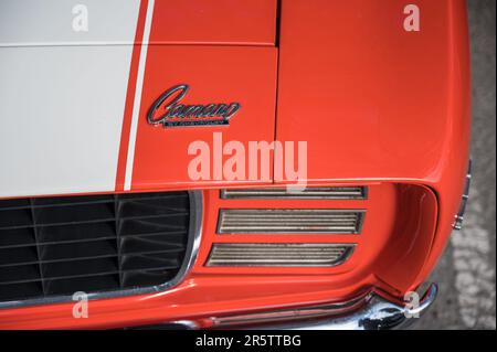 Eine Nahaufnahme eines orangefarbenen Klassikers aus der ersten Generation des Chevrolet Camaro 350 auf der Straße Stockfoto