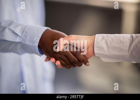Nahaufnahme Des Handshake Symbolisiert Vielfalt Und Zusammenarbeit Im Innenbereich Stockfoto