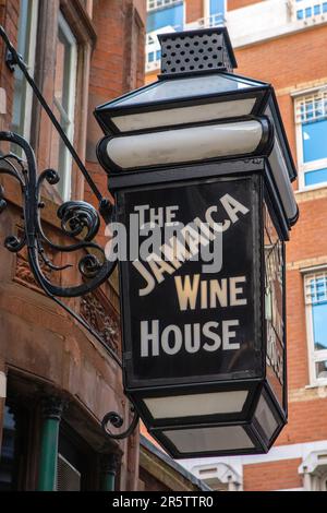 London, Großbritannien - April 17. 2023: Das Schild über dem Eingang zum Jamaica Wine House Pub, in St. Michaels Alley in der City of London - der Geburtsort Stockfoto