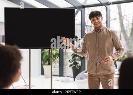 Ein Arabischer Geschäftsmann, Der Auf Einen Großen Bildschirm Zeigt Und Startup Ideas Indoors Präsentiert Stockfoto
