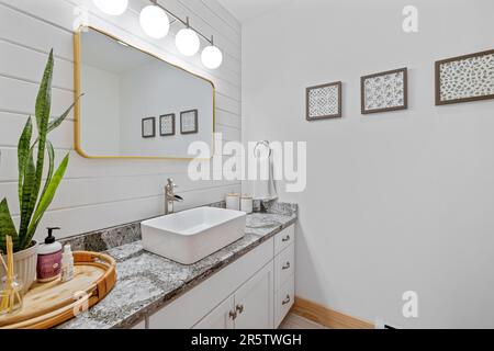 Ein modernes Badezimmer mit einem weißen Marmorablagefach mit Waschbecken Stockfoto