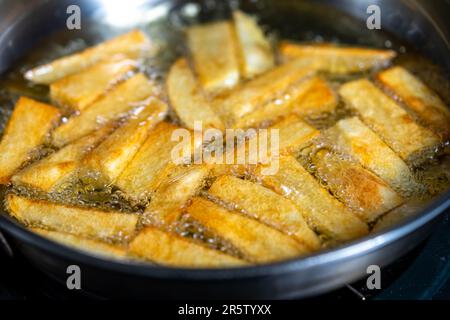 Handgeschnittene Kartoffeln, die in einem Topf braten. Über Schuss Stockfoto
