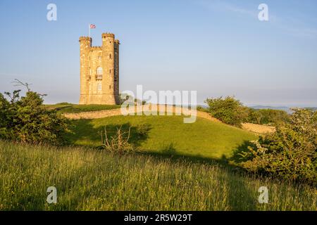 Die Morgensonne scheint auf dem Broadway-Turm auf den Cotswold Hills von Worcestershire. Stockfoto