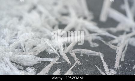 Eis- und Schneekristalle bilden Spitzenformen auf gefrorenem Fluss, Nahaufnahme Makrodetails, abstrakter Winterhintergrund Stockfoto