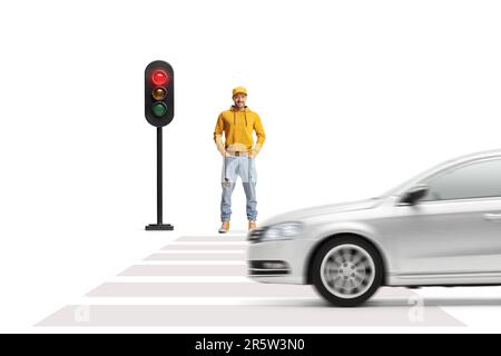 Ein langes Porträt eines jungen Mannes, der auf ein grünes Licht am Fußgängerübergang wartet, isoliert auf weißem Hintergrund Stockfoto