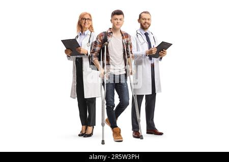 Ärzteteam hinter einem männlichen Schüler mit isolierten Krücken auf weißem Hintergrund Stockfoto