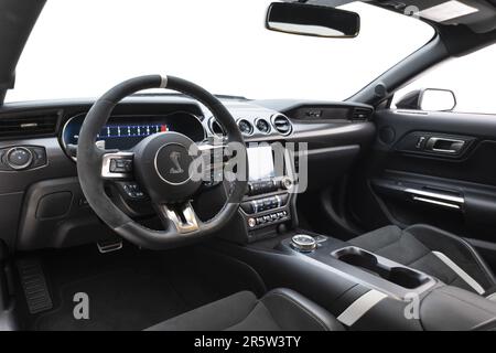 Das Interieur eines Autos, in dem das schwarze Armaturenbrett und der Fahrersitz in Schwarz dargestellt werden Stockfoto
