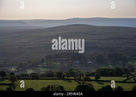 Das Morgenlicht scheint auf dem Gibbet Hill und den fernen Hügeln der Willsworthy Range in Dartmoor, wie sie vom Brent Tor Hill in West Devon aus zu sehen sind. Stockfoto