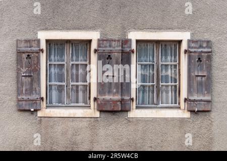 Alte Holzfenster mit rustikalen Fensterläden an einer alten Wand Stockfoto