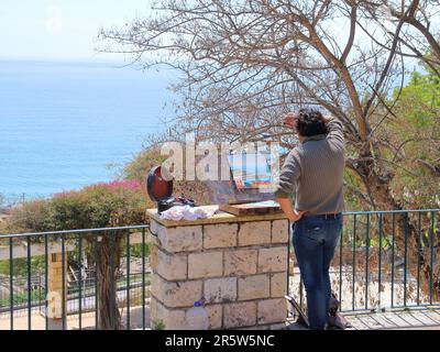 Das Foto wurde im Frühling in Spanien aufgenommen. In dem Bild wurde ein junger Künstler im kreativen Prozess aufgenommen. Er schreibt Landschaft. Stockfoto