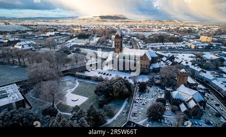 Aus der Vogelperspektive sehen Sie eine schneebedeckte Stadt mit verschiedenen Gebäuden und Straßen Stockfoto
