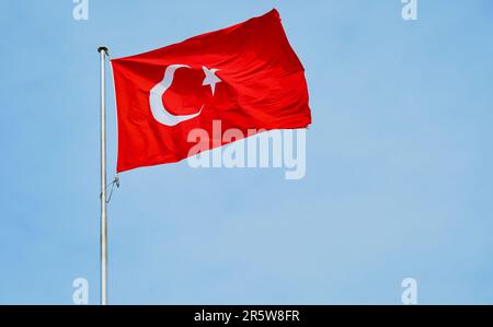 Die türkische Flagge flattert im Wind vor einem blauen Himmel, Hintergrund mit Kopierraum Stockfoto