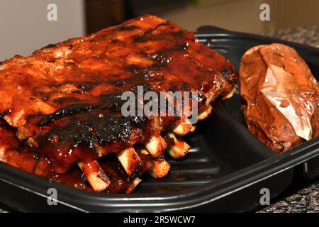 Gegrillte Spareribs in einem Kunststoffbehälter. Grillrippchen. Stockfoto