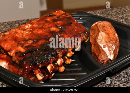 Gegrillte Spareribs in einem Kunststoffbehälter. Grillrippchen. Stockfoto