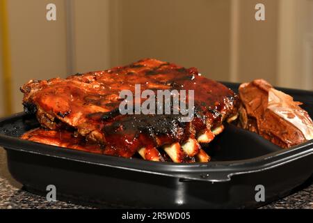 Gegrillte Spareribs in einem Kunststoffbehälter. Grillrippchen. Stockfoto