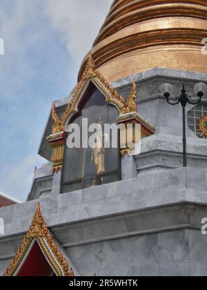 Bangkok, Thailand - August 22. 2010 : Fokus auf eine Buddha-Statue in einem Stück Glas, auf einem Tempel. Das Gebäude ist in einem Slum. Stockfoto