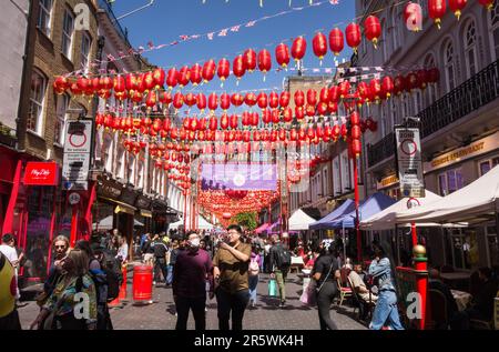 Touristenmassen und rote Papierlaternen auf der Gerrard Street in Chinatown, Soho, im Zentrum von London, England, Großbritannien Stockfoto