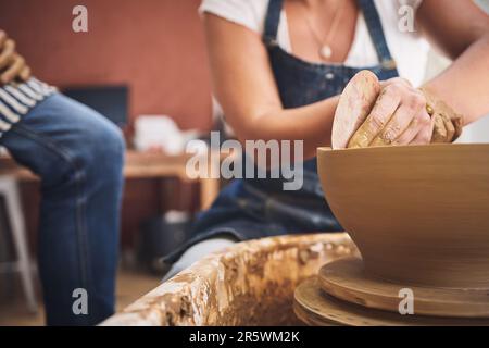 Es gibt etwas an Kunst, das die Seele ernährt. Eine nicht wiedererkennbare Frau, die mit Ton in einem Töpferstudio arbeitet. Stockfoto