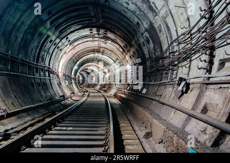 Runder unterirdischer U-Bahn-Tunnel mit Tubing. Stockfoto