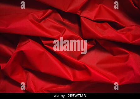 Rotem faltigen Stoff Textur. Nahaufnahme der Textilstruktur werden als Hintergrund verwendet. Stockfoto