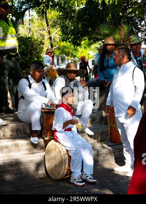 Barranquilla, Kolumbien - Februar 21 2023: Kolumbianische Männer und ein Kind in den traditionellen Kostümen der Küste des Landes sitzen mit ihrem Musical Stockfoto