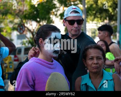 Barranquilla, Atlantico, Kolumbien - Februar 21 2023: Junge kolumbianische Frau mit weißer Gesichtsfarbe und schwarzen Augen trägt ein lila Kostüm bei Carniv Stockfoto