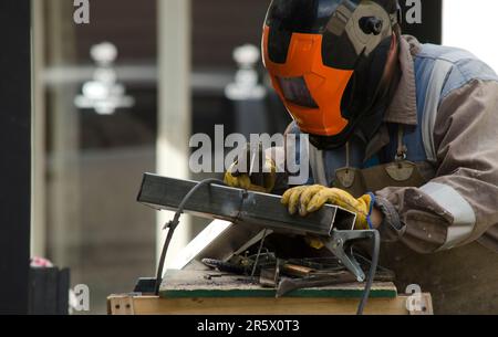 Ein Schmied, der in der Metallbearbeitung mit Werkzeugen einen Metallgegenstand formte Stockfoto