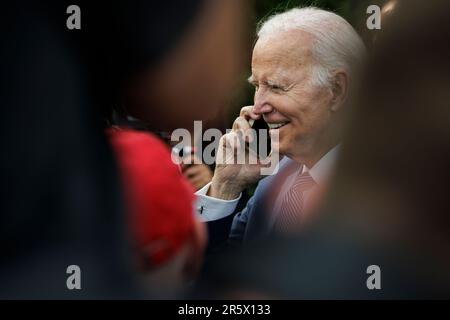 Washington, Usa. 05. Juni 2023. President Joe Biden spricht mit jemandem am Telefon eines Gasts nach einer Veranstaltung zu Ehren der NFL-Meisterschaft der Kansas City Chiefs und ihres Sieges im Super Bowl LVII auf dem South Lawn of the White House am 5. Juni 2023 in Washington, DC (Foto von Samuel Corum/Sipa USA) Credit: SIPA USA/Alamy Live News Stockfoto